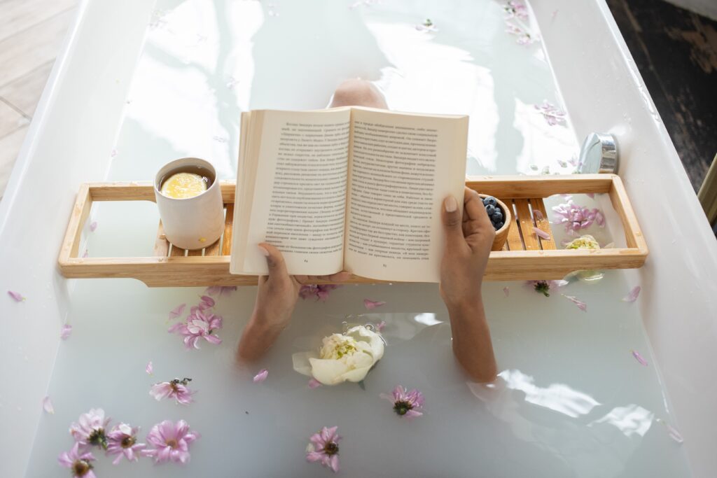 浴室で香水の香りを楽しみながら読書する女性